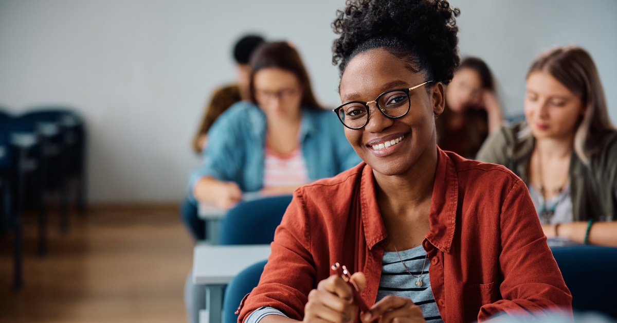 Hymyilevä opiskelija kotoutumiskoulutuksessa luokkahuoneessa